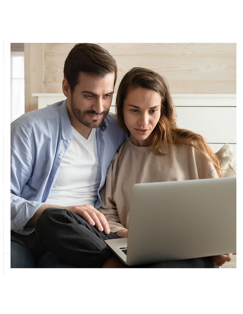 Couple using laptop together at home while learning how to use AI to plan your wedding.